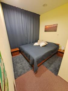 1 dormitorio con 1 cama con cortina azul en Royal Ruse Centre, en Ruse