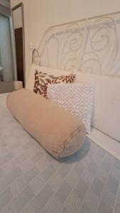ein weißes Bett mit großen Kissen darauf in der Unterkunft Blue Breeze Apartment in Germignaga
