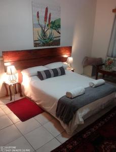 a bedroom with a large bed with two pillows on it at Hippo Farm Apartment in Gobabis