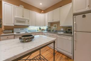 a kitchen with white cabinets and a white refrigerator at Tree House - Downtown Saugatuck - Walk to all the local shops in Saugatuck +13 photos