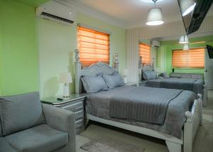 1 dormitorio con cama, silla y espejo en Suite in San Pedro De Macoris en San Pedro de Macorís