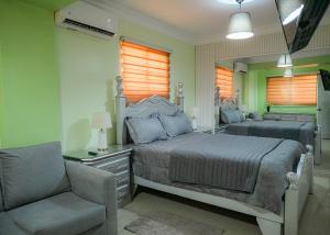 een slaapkamer met een bed, een stoel en een spiegel bij Suite in San Pedro De Macoris in San Pedro de Macorís