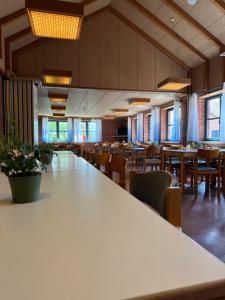 Jugendherberge Tönning في تونينغ: غرفة طعام كبيرة مع طاولات وكراسي
