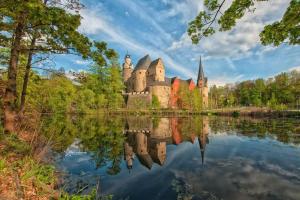 a castle reflected in the water of a lake at Gartentraum, Feuergrill, Kids-Spielwelt, 4Räume in Hartenstein