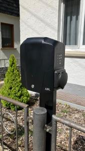 a black tv on a pole next to a fence at FeWo Obstfelderschmiede in Mellenbach-Glasbach