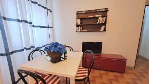 ein Tisch und Stühle mit einer Blumenvase drauf in der Unterkunft Blue Breeze Apartment in Germignaga