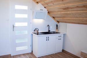 a kitchen with white cabinets and a sink at Apartamenty przy szlaku in Krajno Pierwsze