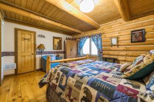 um quarto com uma cama num chalé de madeira em Log cabin- Lake- kayaks- close to South Haven em Paw Paw