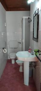 ein Badezimmer mit einem weißen Waschbecken und einem WC in der Unterkunft Mandra Chiusilla in Collesano