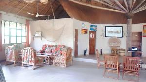 a living room with a couch and chairs and a table at 3 bedrooms house at Cap Skirring 800 m away from the beach with lake view private pool and enclosed garden in Cap Skirring