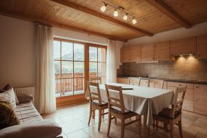 cocina y comedor con mesa y sillas en Refugium LaFlu Apartments, en Corvara in Badia