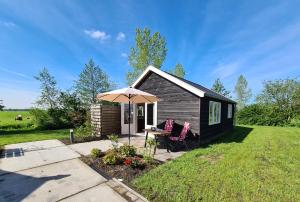 a small cabin with a table and an umbrella at 2-persoons luxe vakantiewoning in De Veenhoop