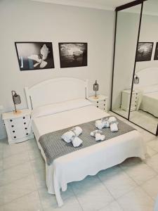 - une chambre blanche avec un lit et des serviettes dans l'établissement Flat Triana, à Las Palmas de Gran Canaria