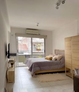 Un dormitorio con una cama y una ventana grande. en MOVISTAR ARENA - Departamento moderno, cómodo, luminoso - Hasta 3 huéspedes - Villa Crespo, en Buenos Aires