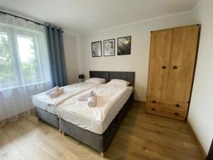 a bedroom with a bed and a large window at Willa Platanowe Wzgórze in Wojcieszyce