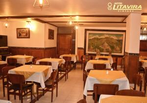 a restaurant with tables and chairs and a painting on the wall at Hotel Litavira Vintage in Sogamoso