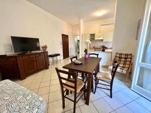 ein Wohnzimmer mit Esstisch und Küche in der Unterkunft Viareggio on the Beach - Apartment in Viareggio