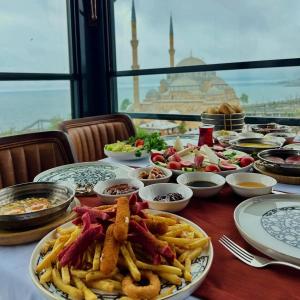 stół z talerzami jedzenia i frytek w obiekcie AYATOURE HOTEL w mieście Bulancak