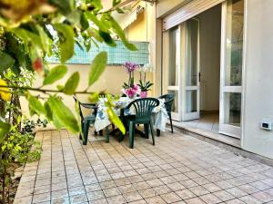 eine Terrasse mit Tisch und Stühlen auf einer Veranda in der Unterkunft Viareggio on the Beach - Apartment in Viareggio