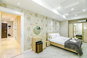 um quarto com uma cama e um espelho na parede em Park Azure Luxury apartment by Baku Housing em Baku