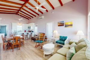 a living room with a couch and a table and chairs at HB21 Austin Cottage in Holden Beach