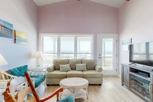 a living room with a couch and a television at HB21 Austin Cottage in Holden Beach