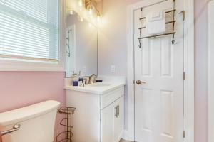a white bathroom with a sink and a mirror at HB21 Austin Cottage in Holden Beach +14 photos
