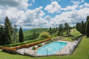 a swimming pool in a garden with flowers at Casali San Gimignano by Mmega in Libbiano