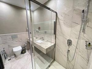 a bathroom with a shower with a sink and a toilet at Arena Grand Hotel in Quba