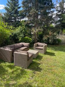 two wicker chairs and a couch in a yard at Apartment with garden in Krems an der Donau