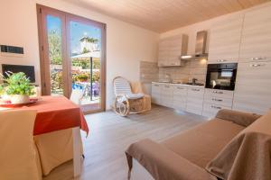 a kitchen and living room with a table and chairs at Cottage Le Dune in Lacona