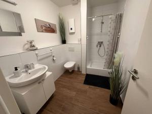 La salle de bains est pourvue d'un lavabo, de toilettes et d'une douche. dans l'établissement Ferienzimmer in Euskirchen, à Euskirchen