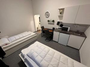a room with two beds and a kitchen with a desk at Ferienzimmer in Euskirchen in Euskirchen