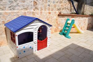 a toy dog house and a slide on a patio at trulli Annina in Locorotondo