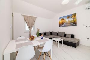 uma sala de estar branca com uma mesa e um sofá em Mit Pool, Balkon unweit von Heilschlamm Bucht em Kras