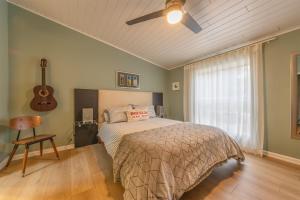 a bedroom with a bed with a ceiling fan and a guitar at Douglas Woods Retreat - Modern Cottage - Newly Remodeled! Walking distance to downtown Douglas! in Douglas