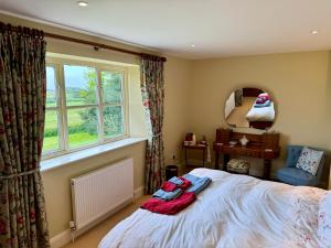 Schlafzimmer mit einem Bett und einem Fenster in der Unterkunft Cockley Hill Farm Bed & Breakfast in Brackley