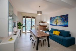 un soggiorno con un divano blu e un tavolo di Appartamento butterfly a Lezzeno