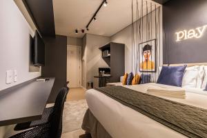 a hotel room with a bed and a tv at Charlie Houx Pinheiros in Sao Paulo