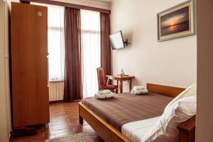 una camera d'albergo con un letto e due asciugamani di Posejdon Resort a Sremska Mitrovica