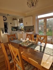 una cucina e una sala da pranzo con tavolo in legno di Troon Open golf - Private house with garden in central Prestwick a Prestwick