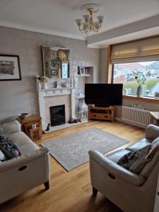 sala de estar con chimenea y TV en Troon Open golf - Private house with garden in central Prestwick en Prestwick