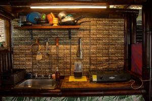 a kitchen with a sink and a counter with a shelf at Cabaña Eco amigable en medio de la montaña. in Pastales