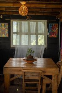 einen Holztisch in einem Zimmer mit Fenster in der Unterkunft Cabaña Eco amigable en medio de la montaña. in Pastales