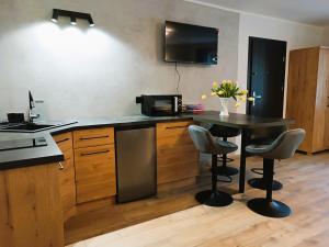 a kitchen with a table with chairs and a microwave at Willa Platanowe Wzgórze in Wojcieszyce