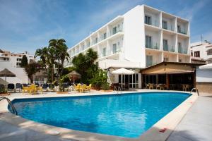 une piscine en face d'un hôtel dans l'établissement Hostal Mar y Huerta, à Es Cana