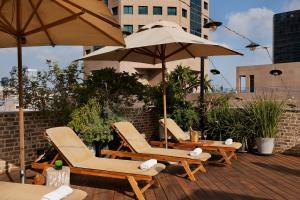 a group of chairs and umbrellas on a deck at The Vera in Tel Aviv