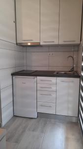 uma cozinha com armários brancos e um lavatório em Apartment HORVAT 2 em Vir