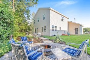a patio with three chairs and a fire pit at Happy Landings - Farmhouse coastal home with tram and stairs to beach access! in South Haven