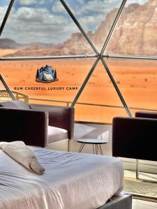 a bed on a boat with a view of the desert at RUM CHEERFUL lUXURY CAMP in Wadi Rum